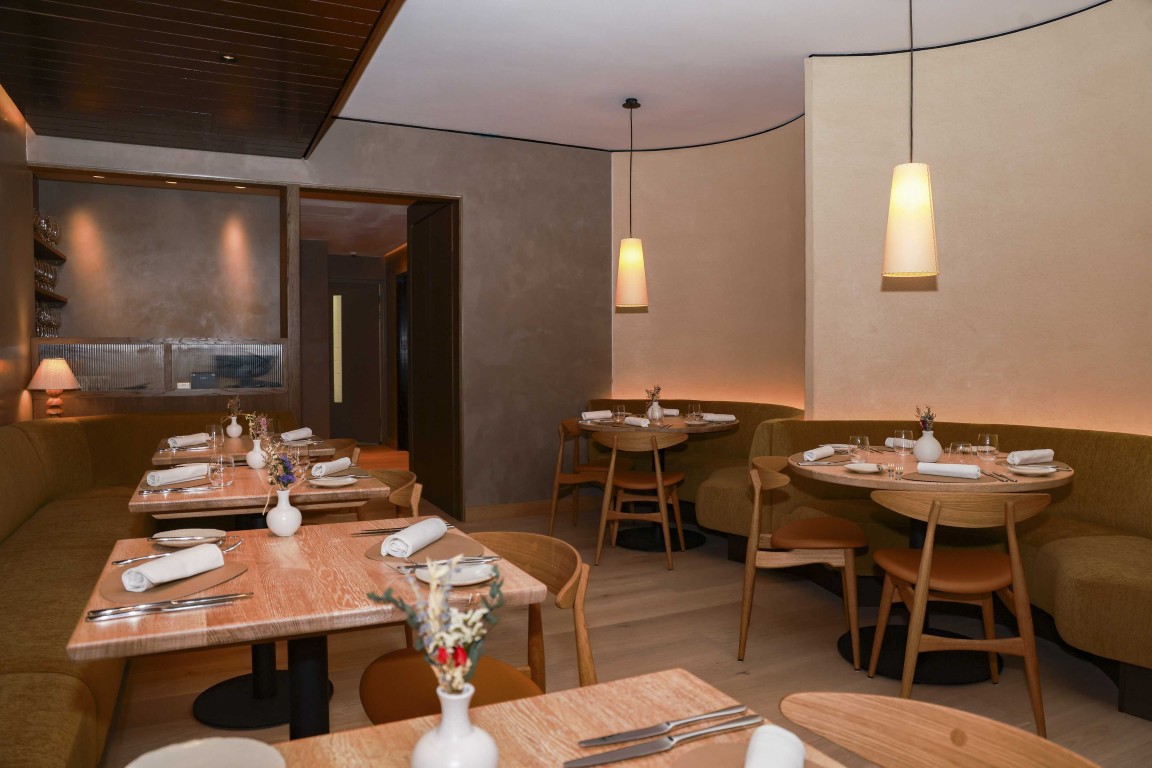 Intimate dining area at 74 Charlotte Street featuring textured Armourcoat Clay Lime Plaster walls, curved banquette seating and warm pendant lighting.