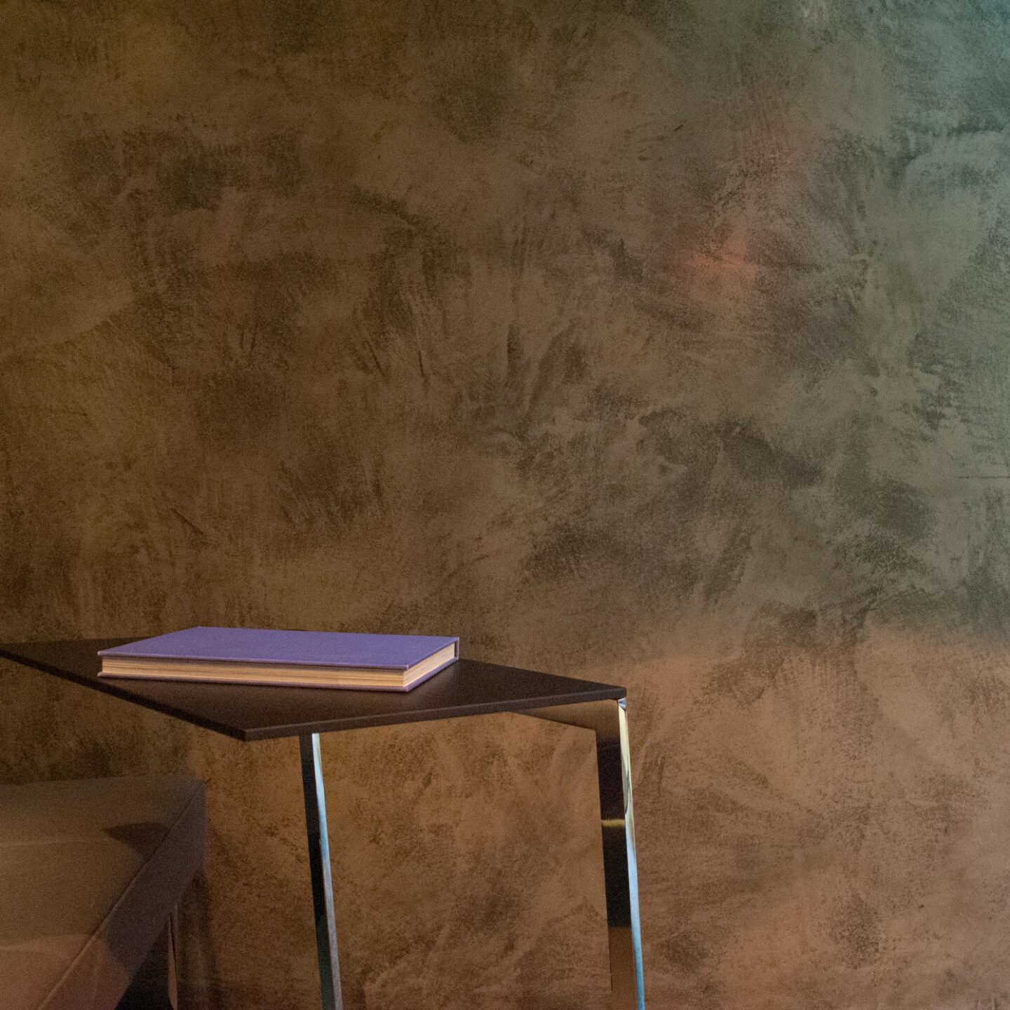 Chair and table in front of wall using Armourcoat Leatherstone Polished Plaster finish, Brunner showroom