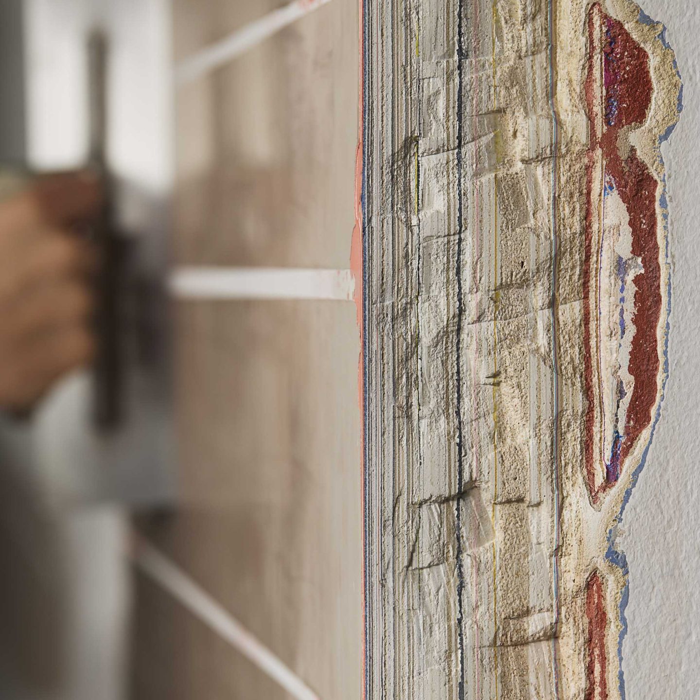 Close-up of layered plaster samples showing varied textures, colours and material finishes in the Armourcoat workshop.