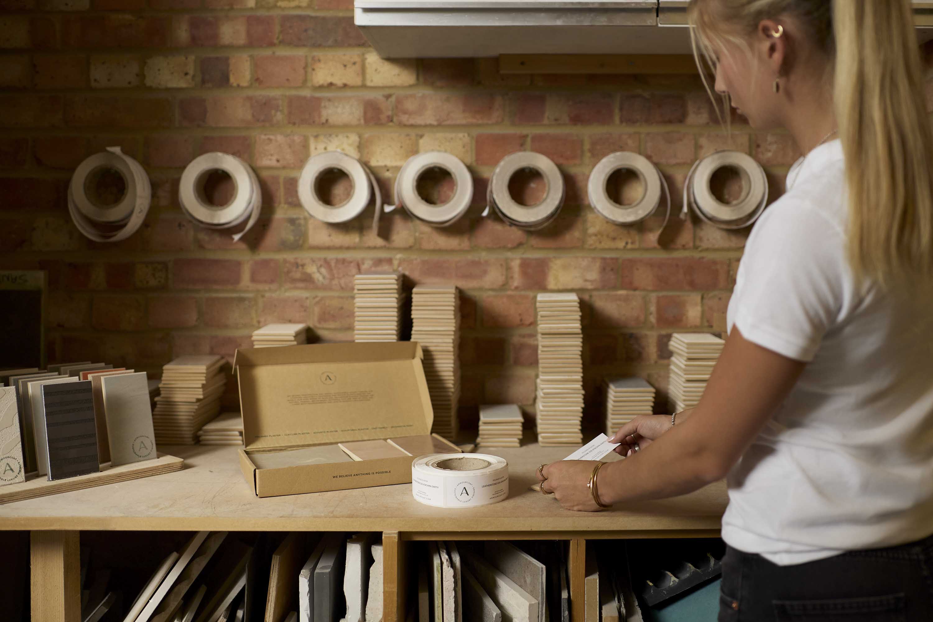 Armourcoat team member preparing and labelling finish samples in the workshop.